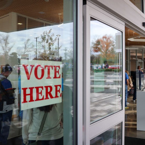 Sign that reads "VOTE HERE" is on the glass door at the Marksbury Family Branch