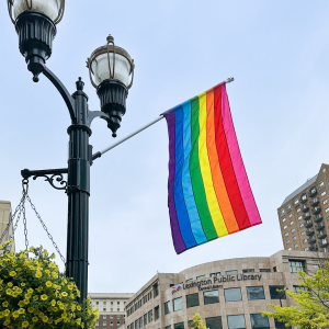 Pride flag hanging from a light pole in front of Central Library 