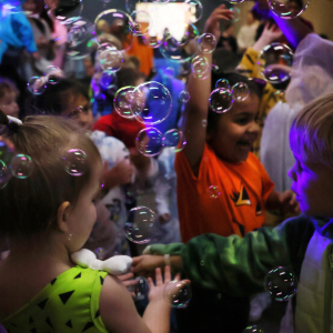 Children ages 5 and under dance in costumes with bubbles to celebrate Halloween at Boo Bash
