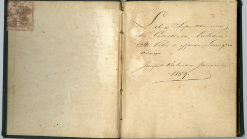Two page book spread with a stamp on the left hand side and Latin text on the right hand side that means "Book of those buried in the St. Peter church cemetery in the City of Lexington. Written the first of January 1859."
