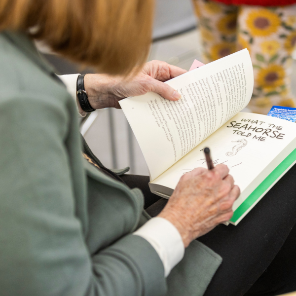 Author May E. Knight signs copy of her book for attendees at a recent author talk event. Explore upcoming author talks at LPL to discuss the book with the authors.