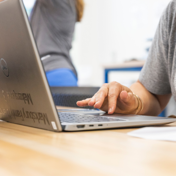 Zoomed in image of hands working on a laptop