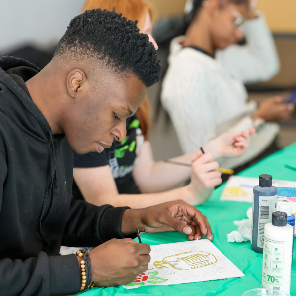 Library patron paints microphone on canvas with fellow crafters at LPL
