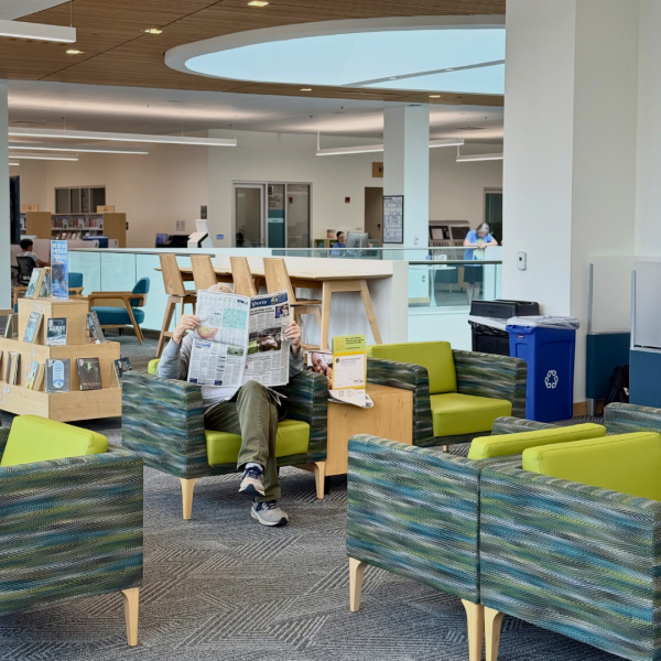 Person sitting in a chair reads the newspaper