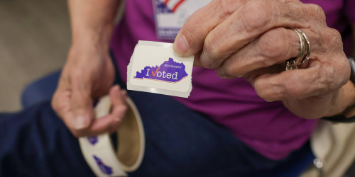 A volunteer passes out an I voted sticker 