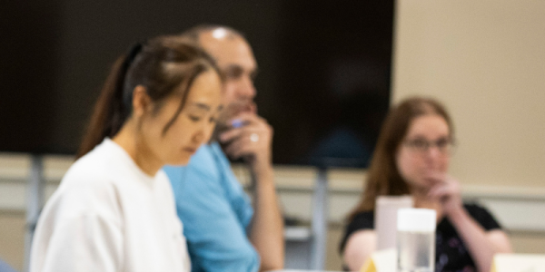 Group of library patrons laugh and discuss a book in a community book club.