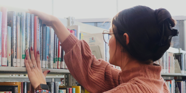 Library staff shelves books in the stacks